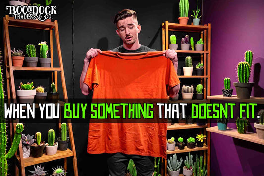 Man with an over sized tshirt, the tee is orange. He is in a trendy room with potted cactus, he looks sad. With the text 'When you buy something that doesn't fit'. The frustration of online shopping and getting the right size for your items streetwear.